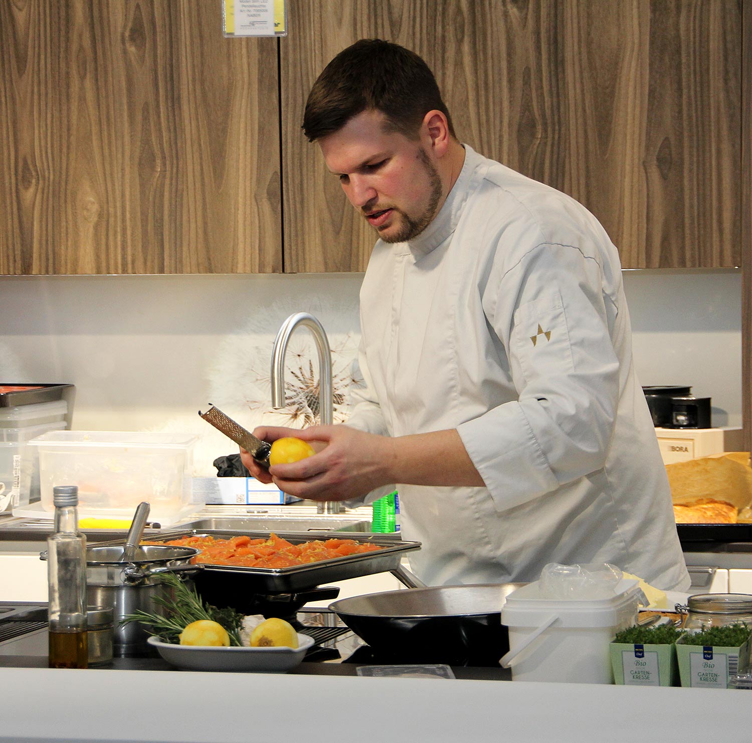 livecooking– Koch bereitet Gericht in moderner Küche zu.